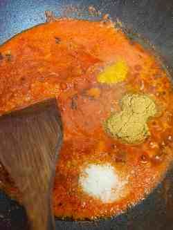 some food is cooking in a pan with a wooden spoon