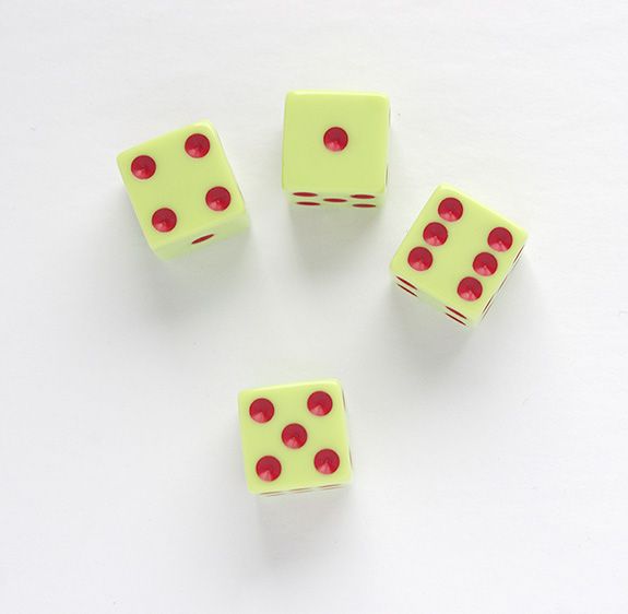 four green dices with red dots are arranged in the shape of a circle on a white surface