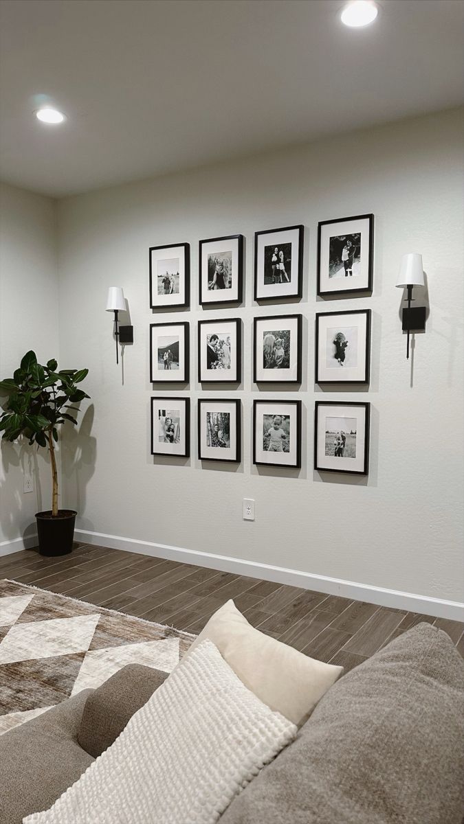 a living room filled with furniture and framed pictures on the wall above it's couch