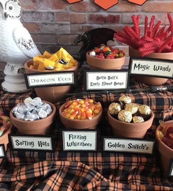 a table topped with lots of different types of candies and chocolates next to a brick wall