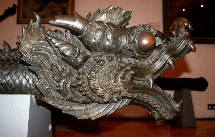 a metal dragon sculpture on display in a museum