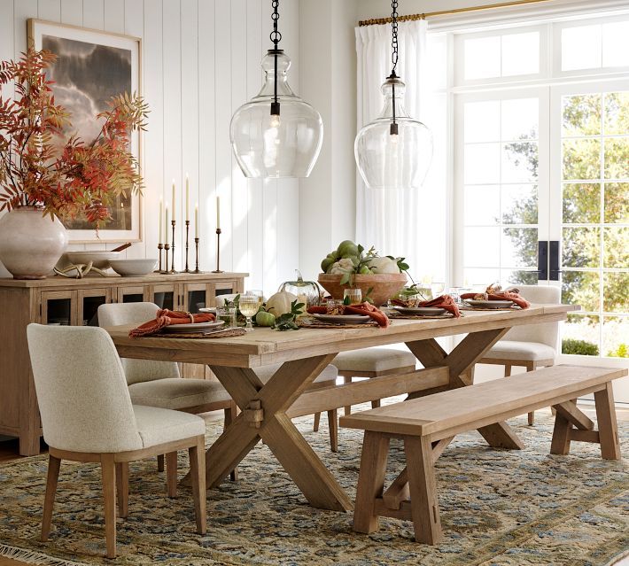 a dining room table with chairs and a bench