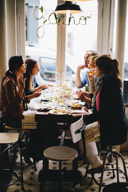 a group of people sitting around a table eating food