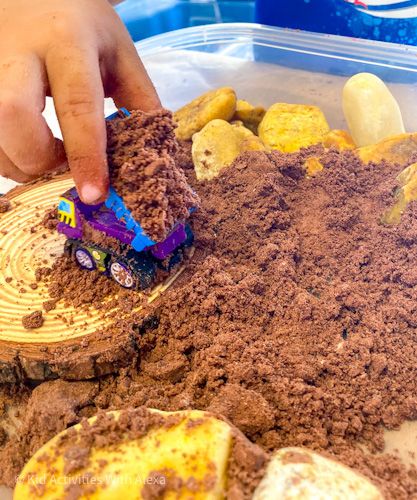 a child is playing with dirt and rocks