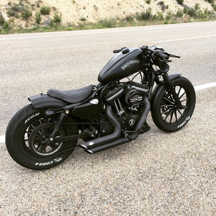 a black motorcycle is parked on the side of the road