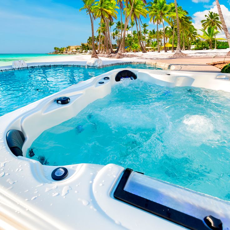 an outdoor jacuzzi is shown with palm trees in the background and blue water