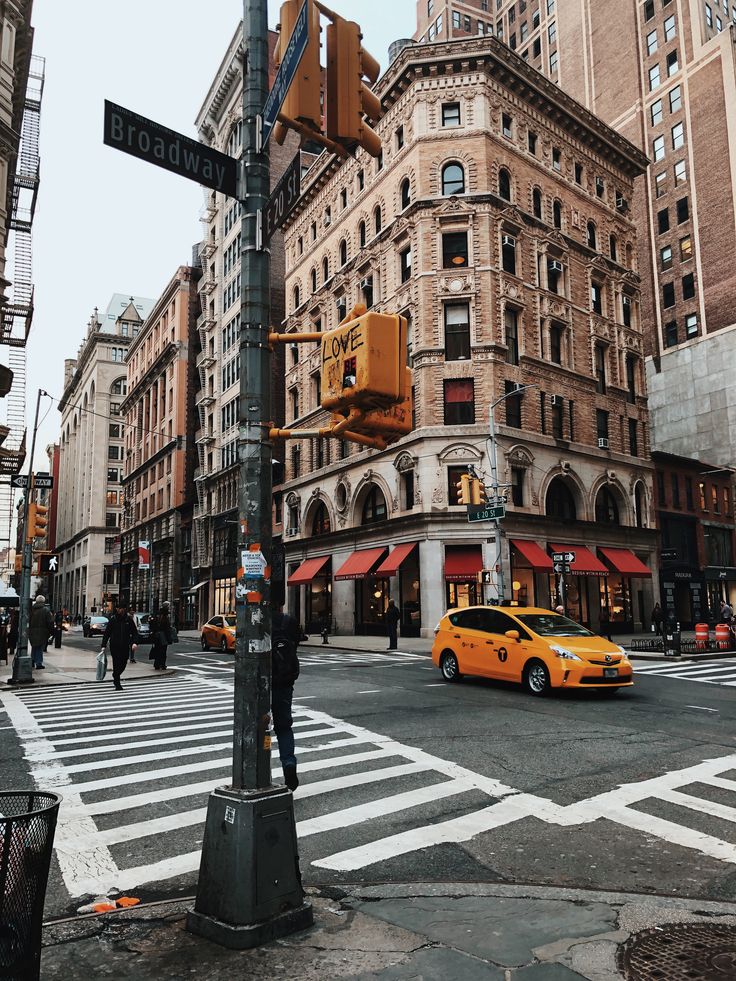 a yellow taxi is stopped at an intersection in new york city's financial district