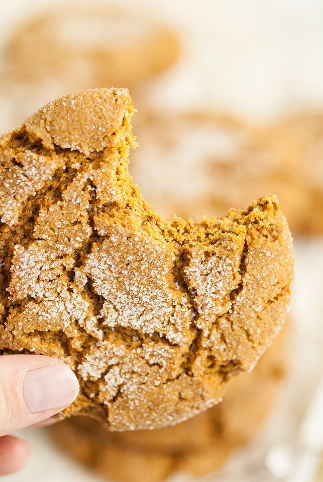 a hand holding up a cookie that has been bitten in half