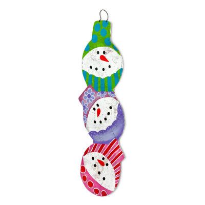 three snowmen hanging from the side of a christmas ornament on a white background