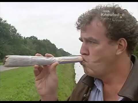 a man is drinking from a long tube