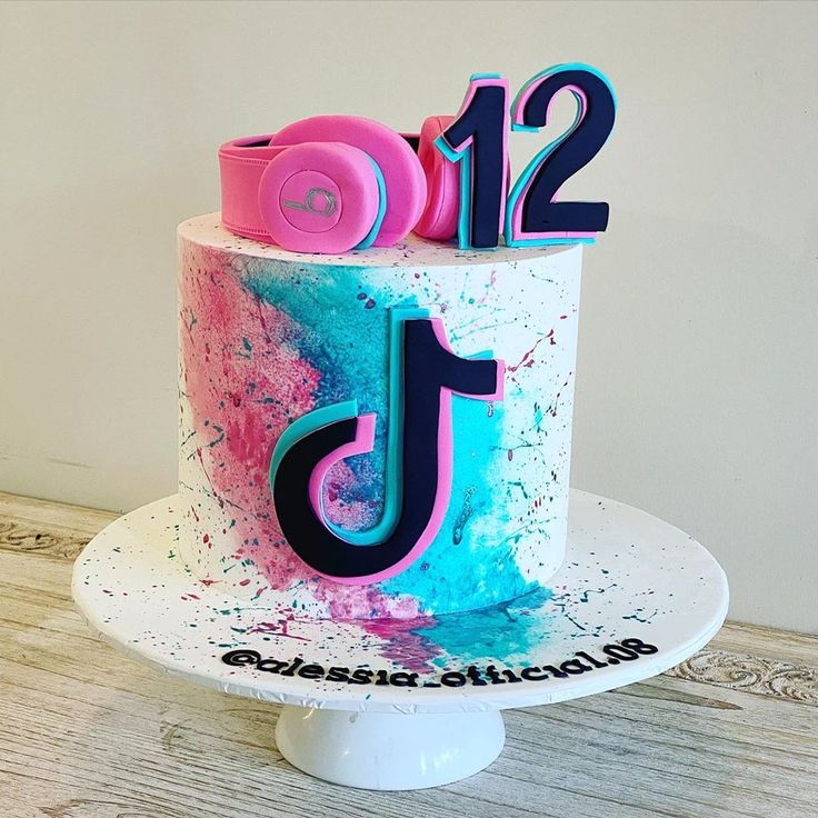 a decorated birthday cake with the number twelve on it's side and splattered icing