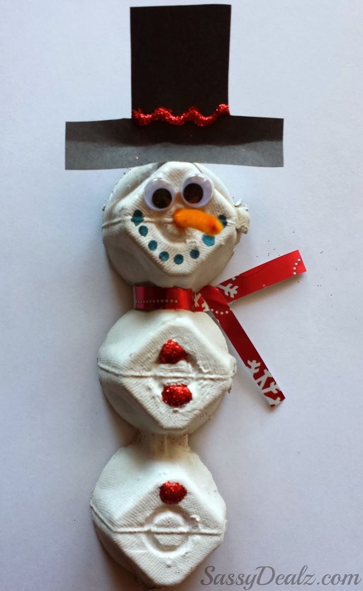 a snowman made out of candy on top of a white surface with a red ribbon