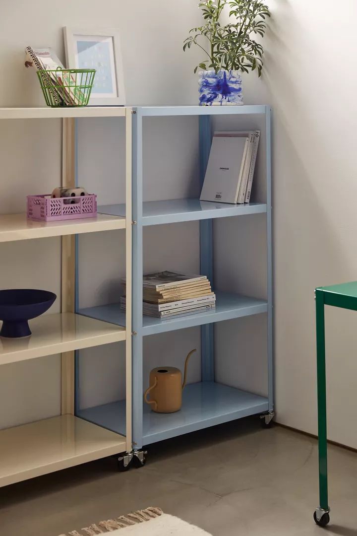 a blue shelf with some books on it and a potted plant next to it