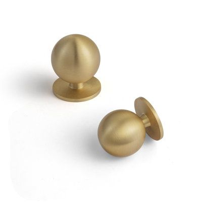 two brass knobs on white background