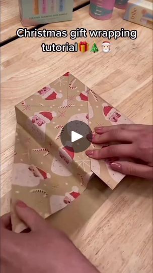 someone is wrapping up a gift box on top of a wooden table with the text, christmas