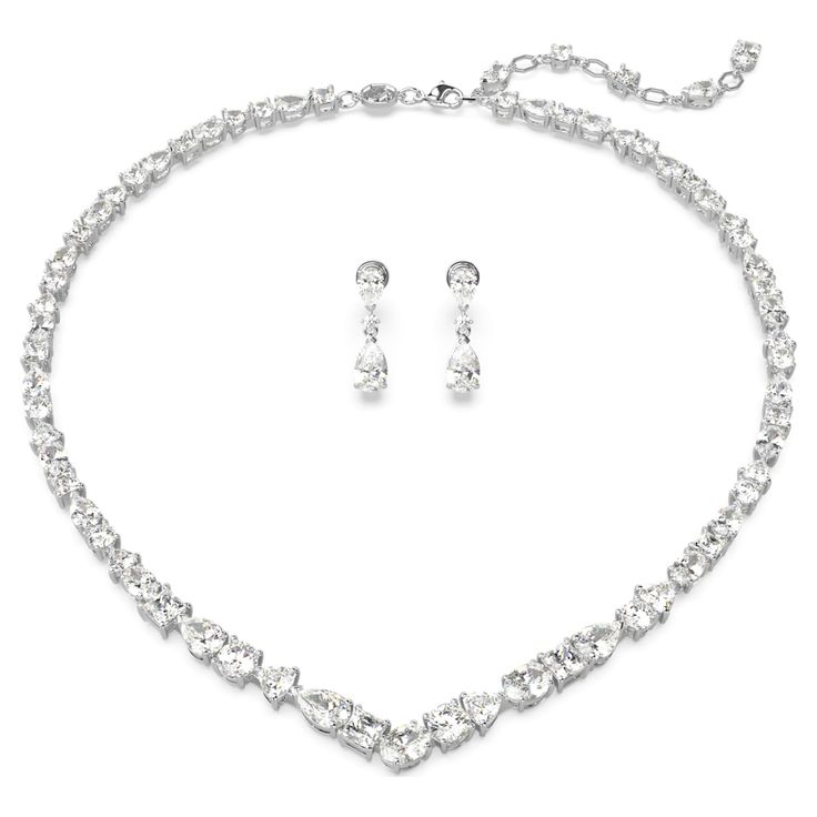 Exquisite refinement is brought to life in this show-stopping jewelry set from the Mesmera family. The necklace is made with a string of eye-catching Swarovski Zirconia on a rhodium plating setting, all produced in a surprising mix of cuts and sizes. For extra luxury, the elongation is completed with a lobster closure and a scattering of Swarovski Zirconia. The light-catching earrings are also rhodium plated, with a bold hanging design featuring luminous pear-cut crystals. Gift this set to a lov Swarovski Earrings Crystals, Swarovski Jewelry Set, Swarovski Necklace Crystal, White Silver Jewelry, Swarovski Jewelry Aesthetic, Classy Necklaces, Jewelry For Bride, Jewelry Set Gold, Swarovski Jewelry Necklace