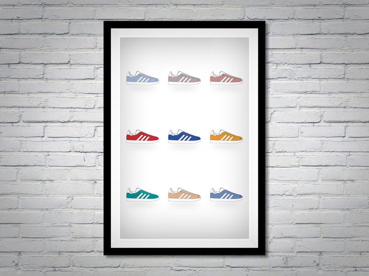 a white brick wall with a black frame hanging on it and several pairs of shoes in different colors