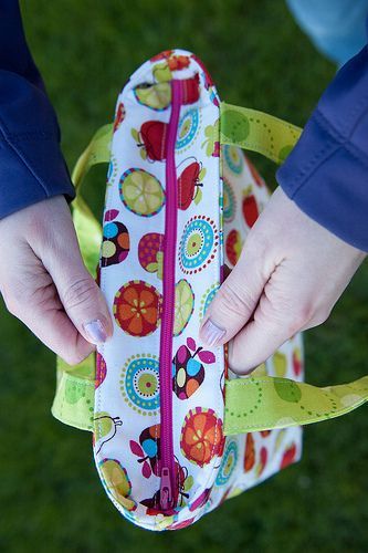 a person is holding a colorful bag in their hands and the bottom part of her purse has flowers on it