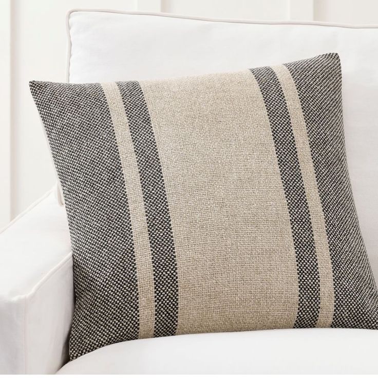 a black and white striped pillow on a white couch