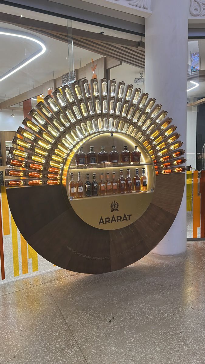 a display in a store filled with lots of bottles on top of a circular shelf