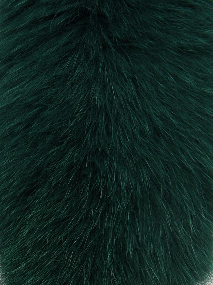 a close up of a green furry object on a white surface