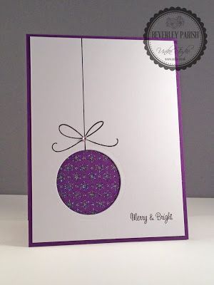 a purple christmas ornament hanging from a string on a white card that says merry and bright