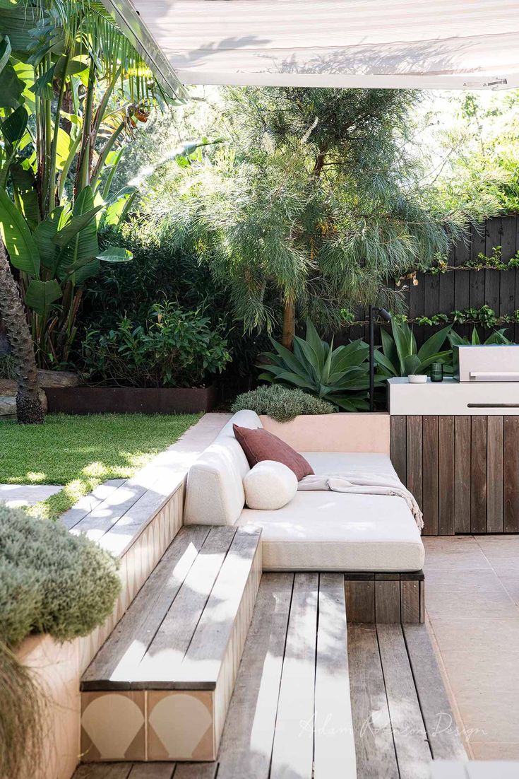 an outdoor living area with white furniture and plants