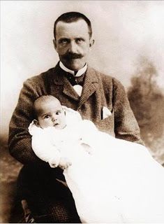 an old photo of a man holding a baby