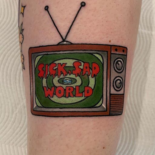 a tattoo on the leg of a person with a tv and words stick - rad world