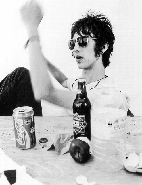 a man sitting at a table with two cans of beer in front of his face