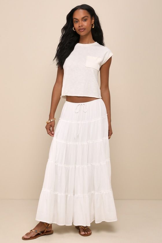 Summer dressing with be effortlessly sweet when you've got the Lulus Relaxed Charm White Gauzy Tiered Drawstring Maxi Skirt! Gauzy, lightweight cotton-blend woven fabric shapes this cute and effortless skirt that has a high-rise silhouette with an adjustable drawstring waist and a tiered design that falls to a flaring maxi hem. Fit: This garment fits true to size. Length: Ankle length. Size medium measures 36.5" from waist to hem. Waist: Fitted - elastic waist allows stretch. Hip: Not Fitted - f Breezy Cotton Bottoms For Day Out, Chic Cotton Beach Skirt, Chic Cotton Skirt For Beach, Chic Cotton Skirt For The Beach, Spring Cotton Maxi Skirt With Elastic Waistband, Casual Maxi Skirt With Elastic Waistband For Loungewear, White Breezy Cotton Bottoms, Breezy White Cotton Bottoms, Flowy Cotton Maxi Skirt With Elastic Waistband