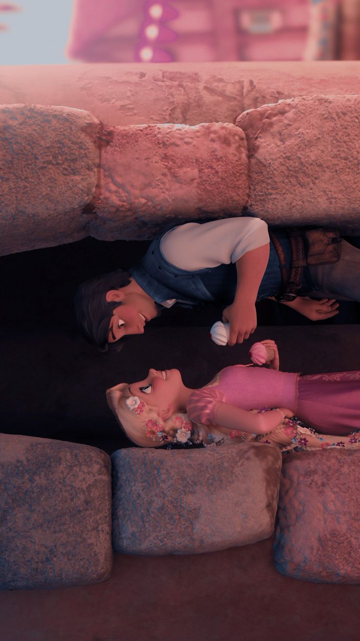 two people laying on the ground next to each other in a cave with rocks surrounding them