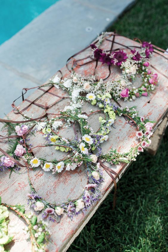 an old table with flowers on it next to a swimming pool in the grass,