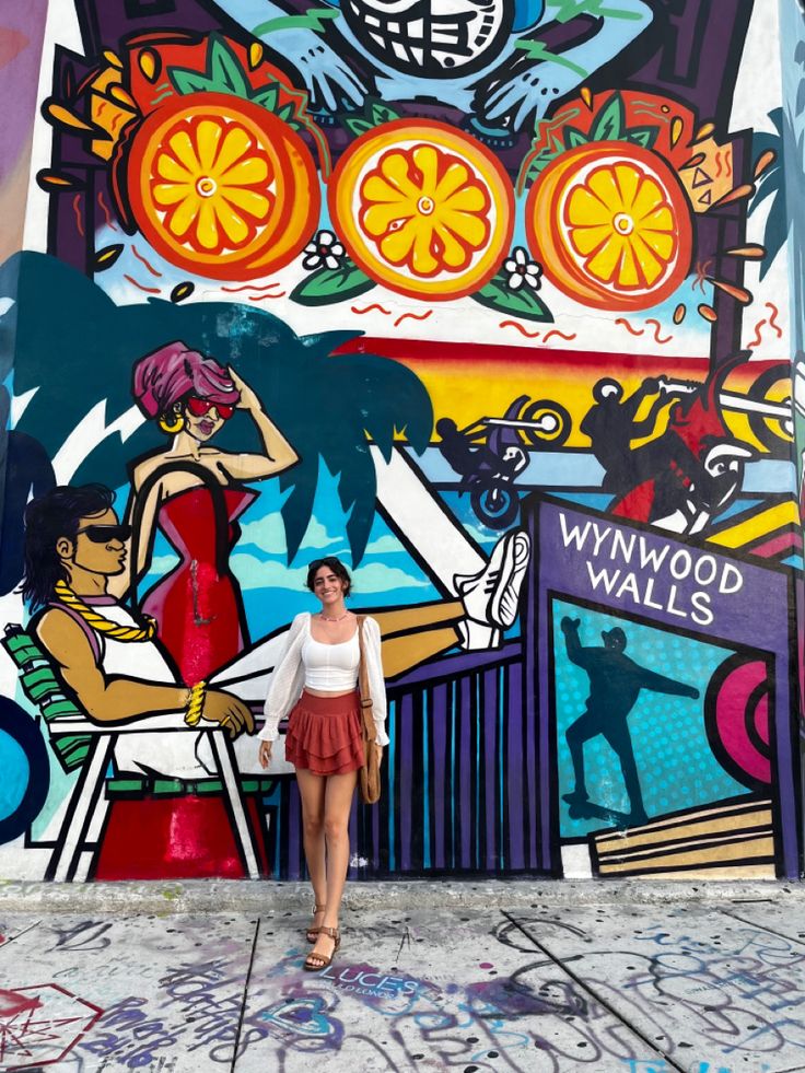 a woman standing in front of a colorful wall