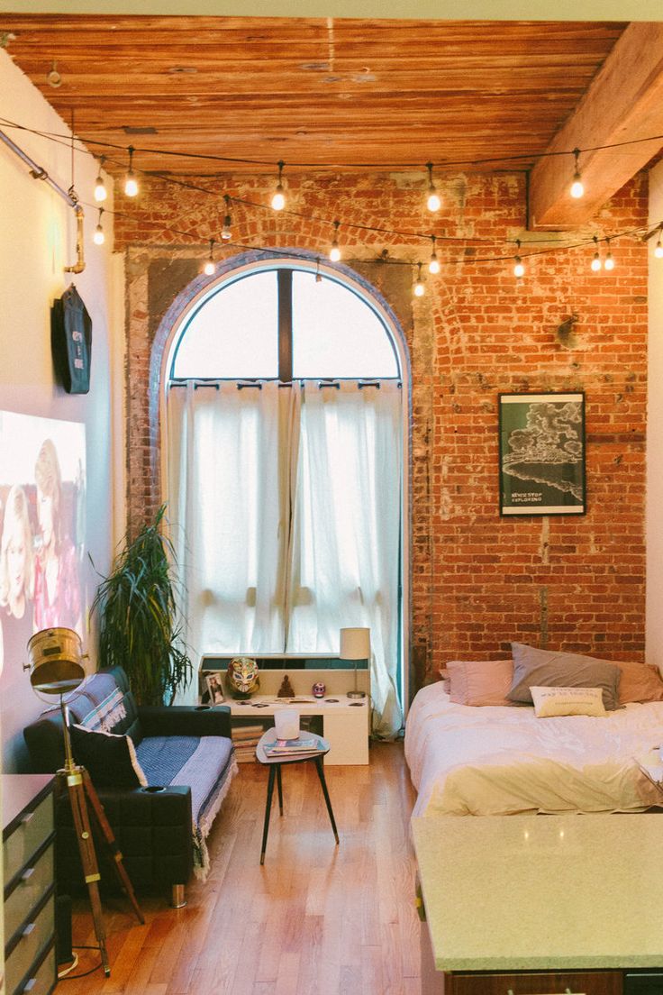 a living room filled with furniture and a brick wall