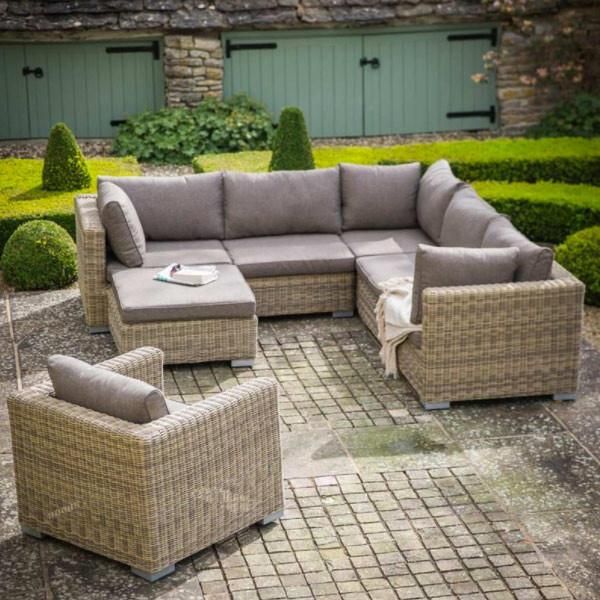 an outdoor seating area with grey wicker furniture