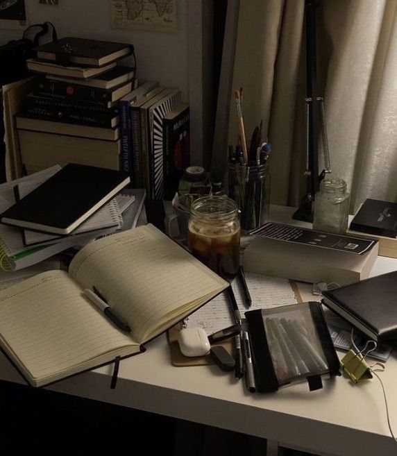 a desk with many books and notebooks on it