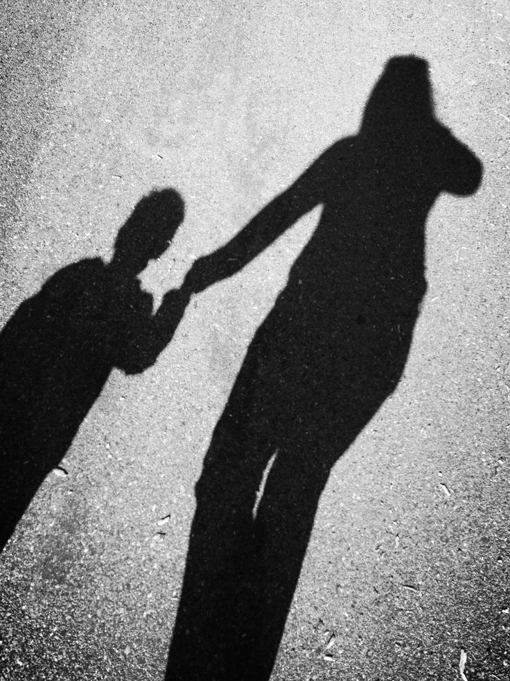 the shadow of two people holding hands