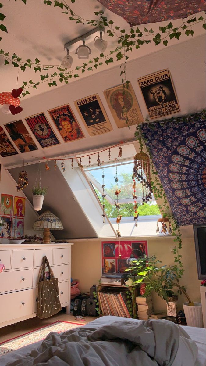 a bedroom with lots of pictures hanging on the wall and plants growing from the ceiling