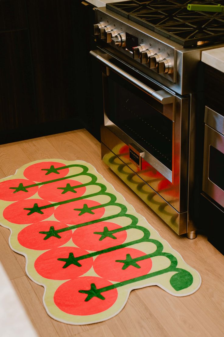 a kitchen area with a stove, oven and rug that says christmas on the floor