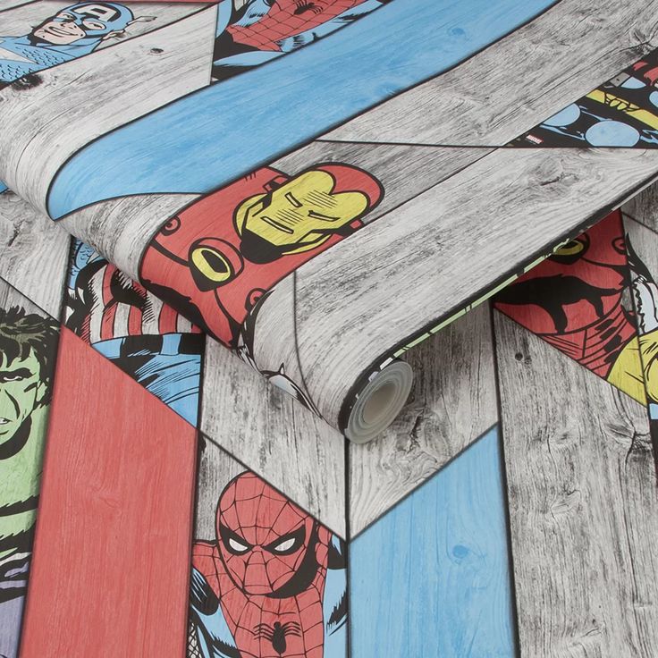 the skateboard is laying on top of the wooden planks that are painted with cartoon characters