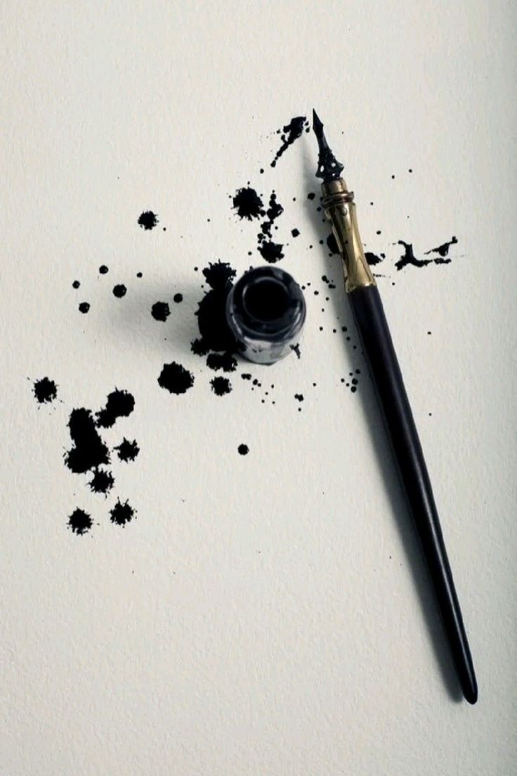 a pen and ink smudges sitting on top of a piece of white paper