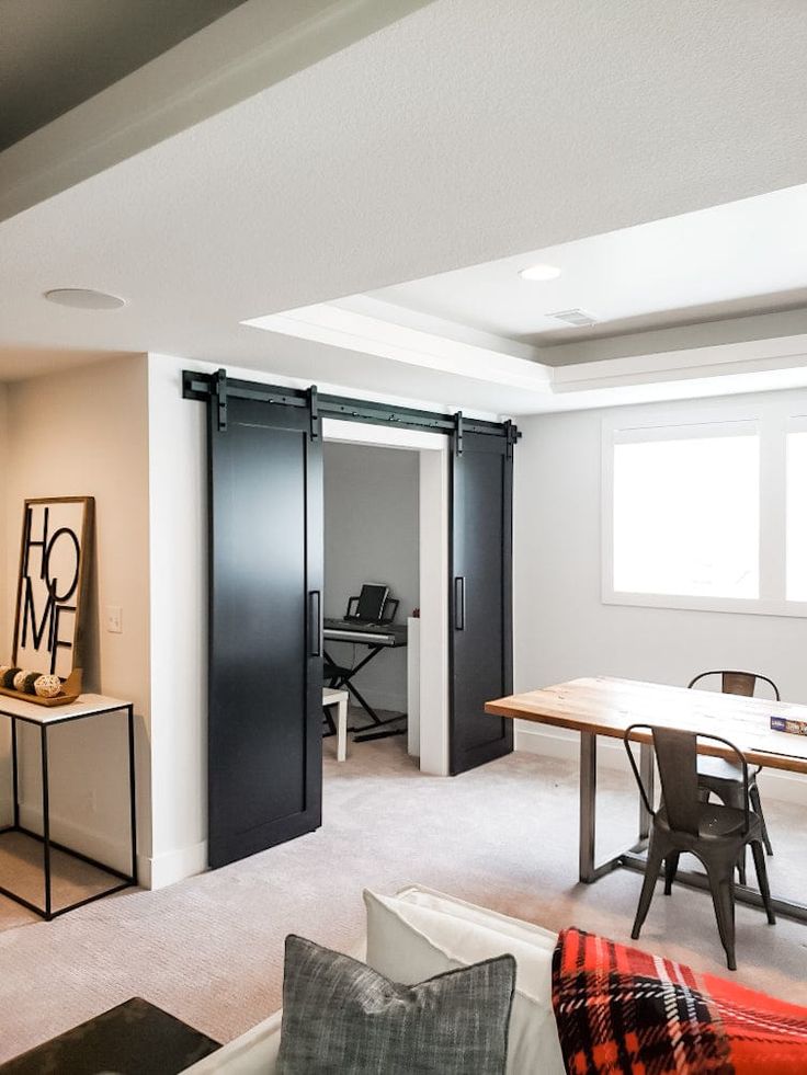 a living room filled with furniture next to a dining table and sliding doors that open