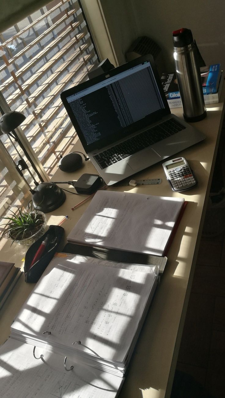 an open laptop computer sitting on top of a wooden desk next to a pair of scissors