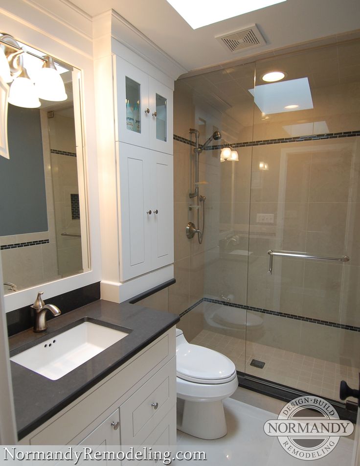 a bathroom with white cabinets and black counter tops