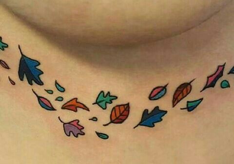 a woman's chest with colorful leaves on the side and back of her neck