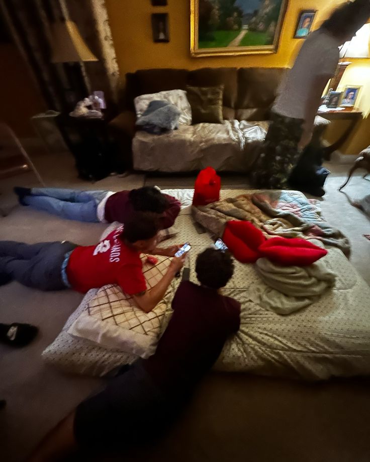 three people laying on the floor in a living room