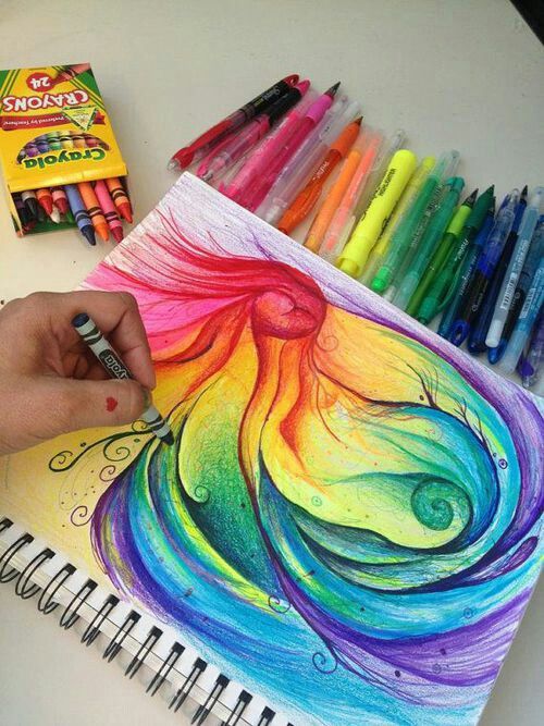 someone is drawing with colored pencils and crayons