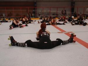 a group of people sitting on the floor in a gym