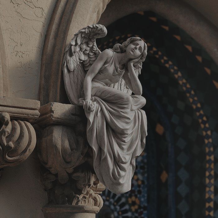 an angel statue sitting on the side of a building